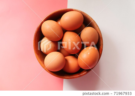 Top view of eggs in a bowl on color background  71967933