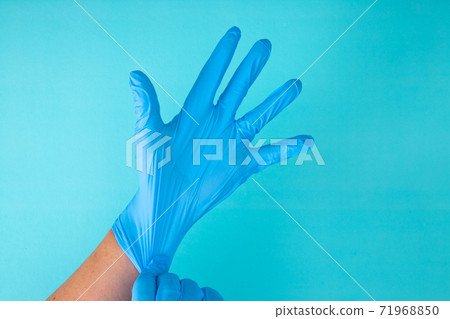 hands wear rubber gloves on a blue background 71968850