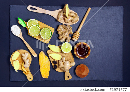 healthcare concept. Ginger dried fruits, honey lime, mango and ingredients on a black grunge stone table. copy space background healthcare concept. Ginger dried fruits, honey lime, mango and ingredients on a black grunge stone table. copy space background 71971777