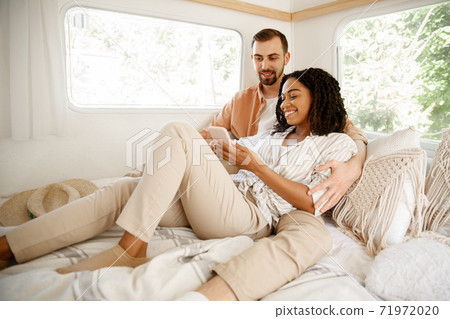 Love couple embraces in rv bed, camping in trailer Love couple embraces in rv bed, camping in trailer 71972020