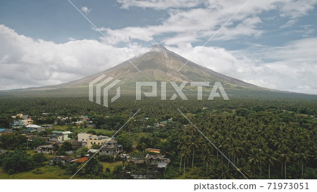 Tropic countryside with palm trees aerial. Mayon volcano hillside valley. Rural cityscape cottages Tropic countryside with palm trees aerial. Mayon volcano hillside valley. Rural cityscape cottages 71973051