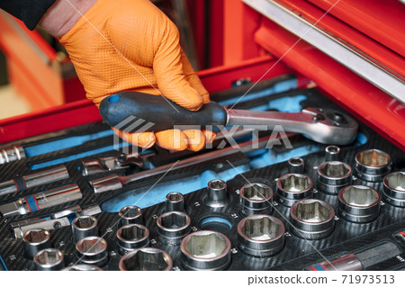 A set of tools for repair in car service - mechanic's hands, close up A set of tools for repair in car service - mechanic's hands, close up 71973513