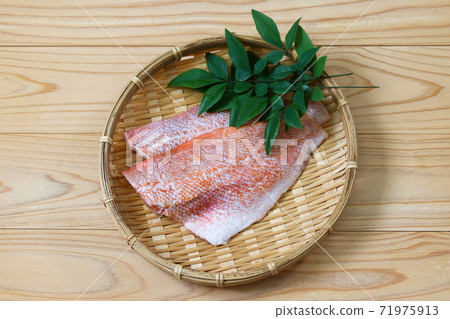 Red fish fillet on a colander 71975913