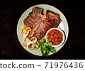Roasted meat on a plate. Restaurant food. Grilled meat steak with sauce. Wooden background. 71976436