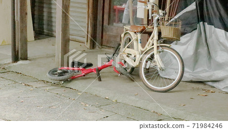 Children's bicycles randomly abandoned at the eaves 71984246