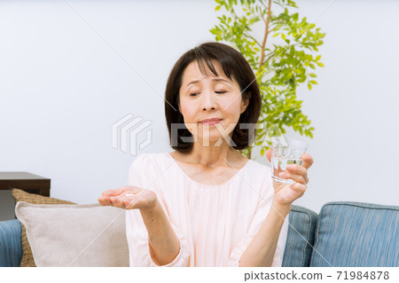 サプリメントを飲む女性 71984878
