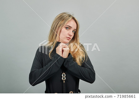 Hugging herself to warm while feeling cold arms crossed fear expression on face Hugging herself to warm while feeling cold arms crossed fear expression on face 71985661