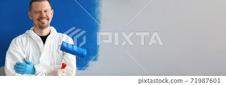 Male painter in uniform with roller in his hand Male painter in uniform with roller in his hand 71987601