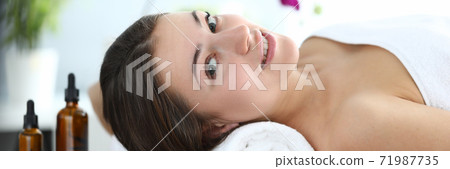 Happy girl is lying in massage room and smiling 71987735