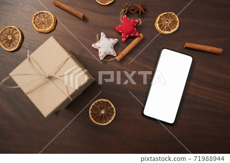 flat lay with smarthone and christmas decorations on walnut table flat lay with smarthone and christmas decorations on walnut table 71988944