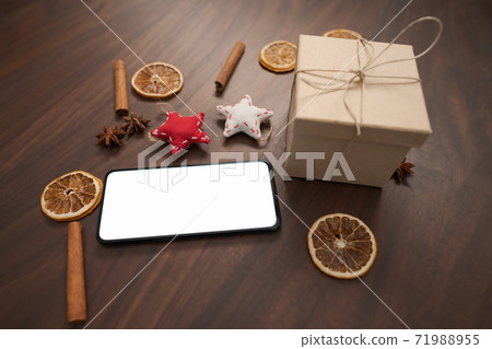 smarthone with white screen and christmas decorations on walnut table 71988955