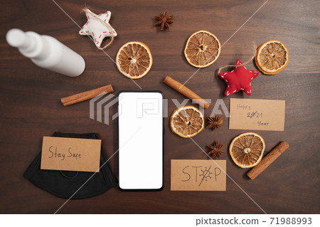 flat lay with smarthone and christmas decorations on walnut table 71988993