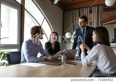 Interested male boss listening to ideas expressed by staff members 71989482