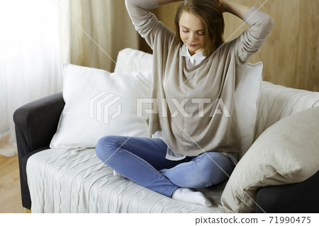 Happy brunette woman put hands behind head sitting leaned on couch european female enjoy lazy weekend or vacation in cozy living room, housewife relaxing feels satisfied after housework 71990475