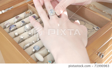 Hands of a woman wearing a ring on a jewelry box Hands of a woman wearing a ring on a jewelry box 71990963