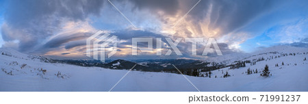 Picturesque winter windy and cloudy morning alps. Ukrainian Carpathians highest ridge is Chornohora with peaks of Hoverla and Petros mountains. View from Svydovets ridge  Dragobrat ski resort. 71991237