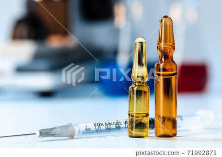 Vial of vaccine bottle with a syringe close up Vial of vaccine bottle with a syringe close up 71992871