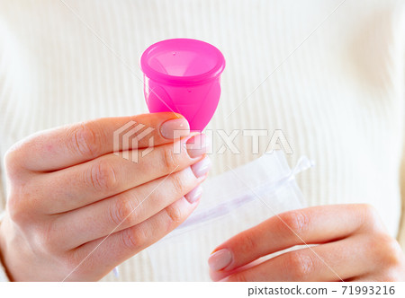 Hands of a woman putting menstrual cup into a bag Hands of a woman putting menstrual cup into a bag 71993216