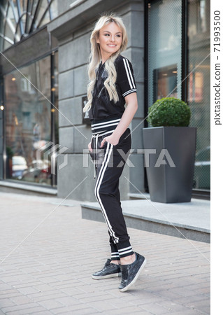Charming woman dressed in sports black suit Charming woman dressed in sports black suit 71993500