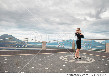 Nice woman wearing in black dress against the backdrop of the volcanoes Batur and Agung Nice woman wearing in black dress against the backdrop of the volcanoes Batur and Agung 71994384