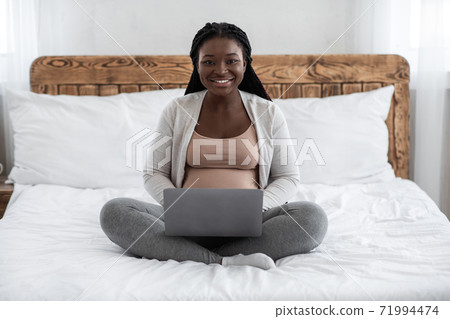 Remote Work For Pregnant Women. Black Expectant Mother Using Laptop At Home Remote Work For Pregnant Women. Black Expectant Mother Using Laptop At Home 71994474
