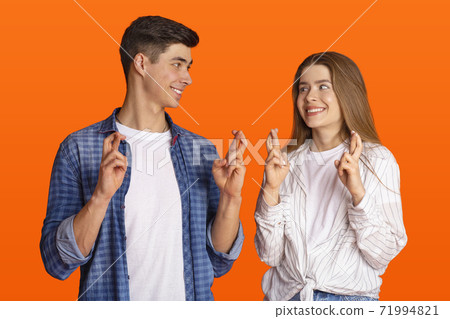 Luck and superstition. Cheerful millennial couple gesturing crossing fingers in hope Luck and superstition. Cheerful millennial couple gesturing crossing fingers in hope 71994821