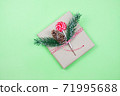 Christmas gift box wrapped in brown craft paper with corn, fir-tree and candy on green background.New Year and Christmas concept. 71995688