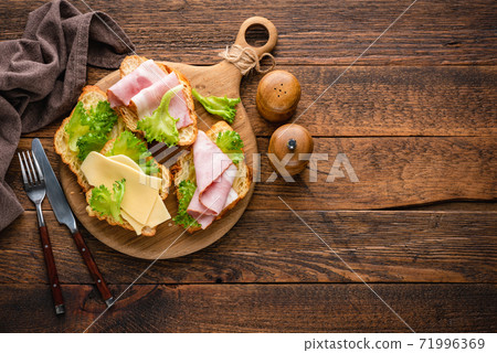 Breakfast croissant with ham, cheese and lettuce Breakfast croissant with ham, cheese and lettuce 71996369