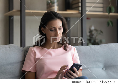 Serious young arabian indian woman using telephone applications. Serious young arabian indian woman using telephone applications. 71996718