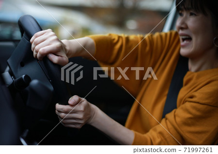 A woman who suddenly turns the steering wheel 71997261
