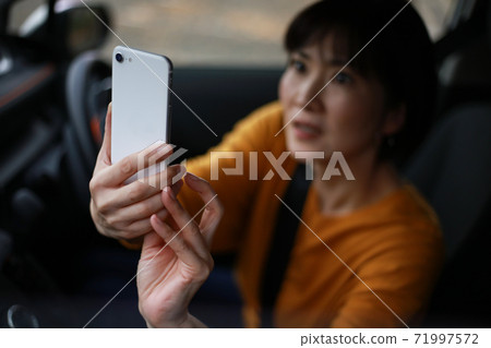 A woman shooting with a smartphone in a hurry A woman shooting with a smartphone in a hurry 71997572