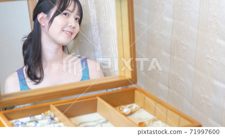 一個女人戴著鑽石穿刺，看著鏡子 71997600