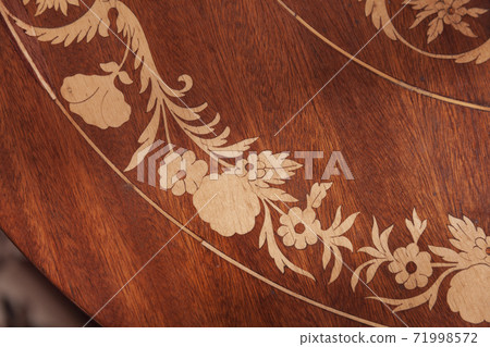 Decorative inlay carving on a wooden table Decorative inlay carving on a wooden table 71998572