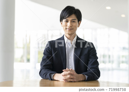 A young man smiling looking at the camera A young man smiling looking at the camera 71998738