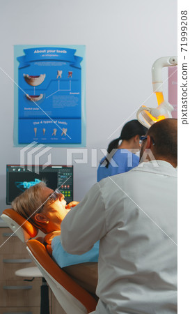 Professional dentist working with gloves during examination Professional dentist working with gloves during examination 71999208