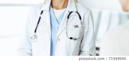 Unknown woman-doctor communicating with female patient. Physician checks medical history record and exam results, close-up. Medicine concept Unknown woman-doctor communicating with female patient. Physician checks medical history record and exam results, close-up. Medicine concept 71999690