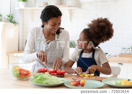 Happy patient black mom teaching little daughter prepare healthy nutrition Happy patient black mom teaching little daughter prepare healthy nutrition 72001654