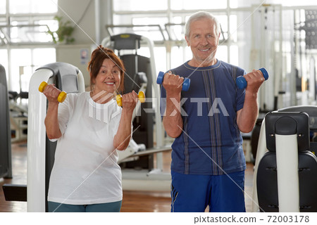 Satisfied senior couple with dumbells at sport club. Satisfied senior couple with dumbells at sport club. 72003178