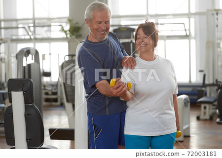 Portrait of smiling senior couple exercising in gym. Portrait of smiling senior couple exercising in gym. 72003181