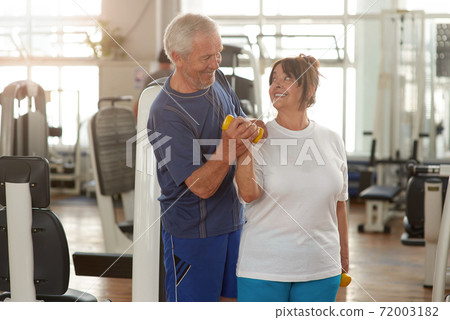 Happy couple of seniors training at gym together. Happy couple of seniors training at gym together. 72003182