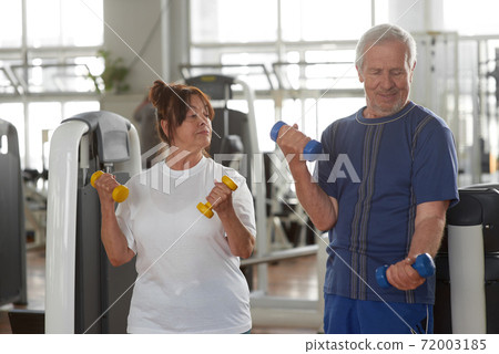 Seniors lifting weights at gym. Seniors lifting weights at gym. 72003185