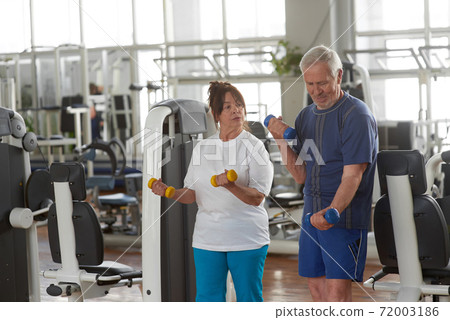 Elderly couple exercising at gym. Elderly couple exercising at gym. 72003186