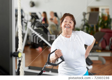 Pretty elderly woman working out at gym. Pretty elderly woman working out at gym. 72003198