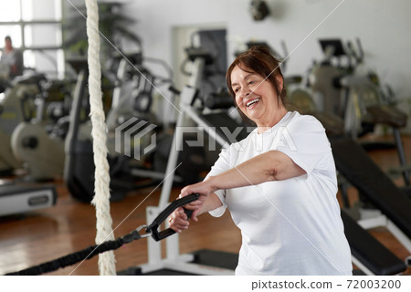 Charming elderly lady working out at gym. Charming elderly lady working out at gym. 72003200