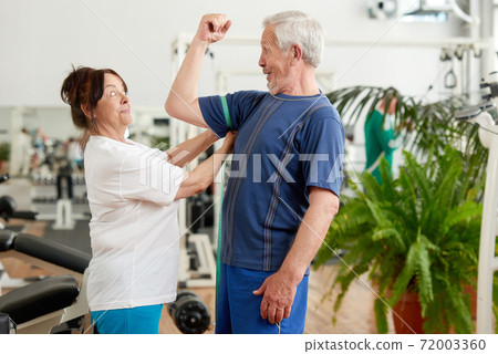 Excited woman measuring bicep of senior man. Excited woman measuring bicep of senior man. 72003360