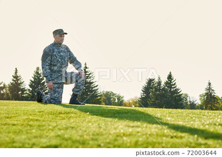 Serious soldier on one knee pose. Serious soldier on one knee pose. 72003644