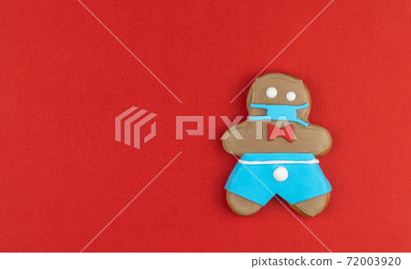 gingerbread man in a medical mask. Medical respiratory bandage face, surgical protective mask. gingerbread man in a medical mask. Medical respiratory bandage face, surgical protective mask. 72003920