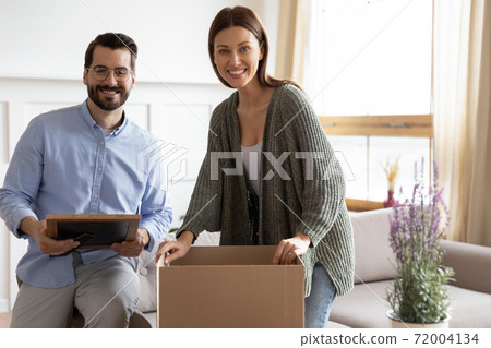 Portrait of happy couple unpack boxes moving together Portrait of happy couple unpack boxes moving together 72004134