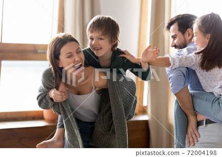 Overjoyed parents have fun playing with children Overjoyed parents have fun playing with children 72004198