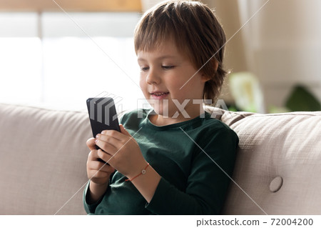 Small boy use smartphone playing game online Small boy use smartphone playing game online 72004200